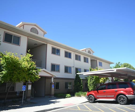 a red car parked in front of a building with a canopy