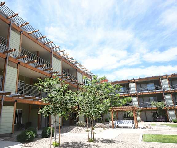 an apartment building with a courtyard and trees in front of it