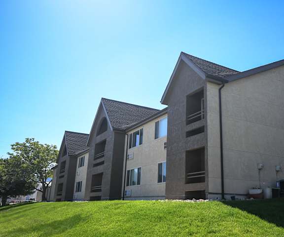 a row of apartment buildings on a green lawn