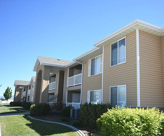 a row of apartments with yellow siding and a blue sky