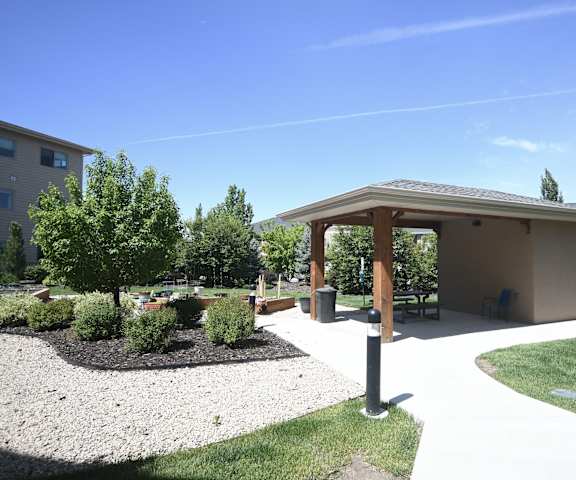 a pavilion in a park with trees and a sidewalk