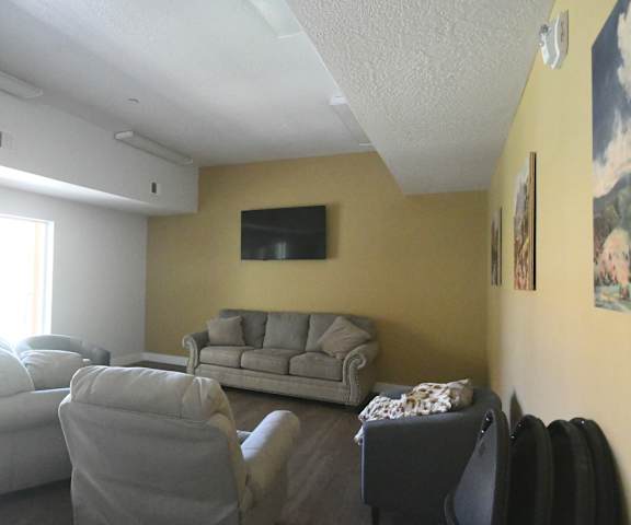 a living room with couches and chairs and a tv