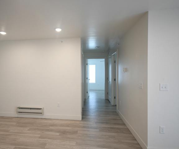 an empty room with white walls and a wood floor
