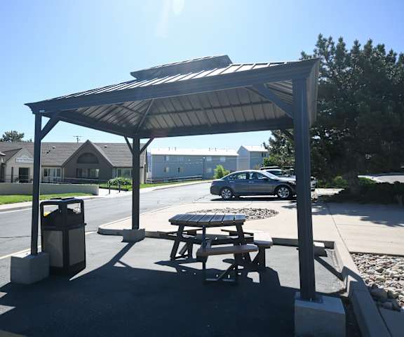 a picnic table and a trash can in a parking lot