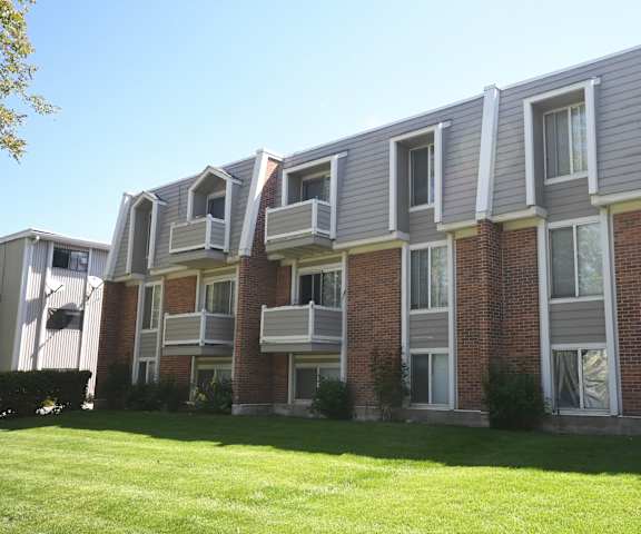 an apartment building with a green lawn in front of it