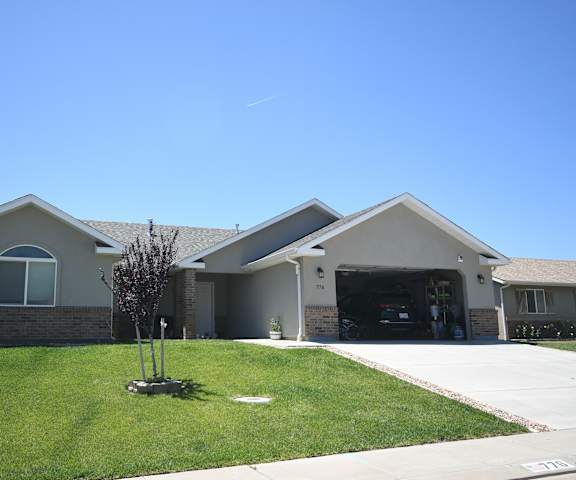 a house with a driveway and a lawn in front of it