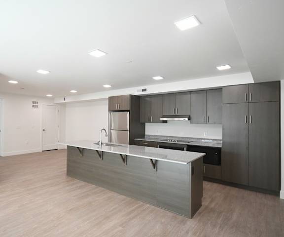 an empty room with an island in the middle of a kitchen
