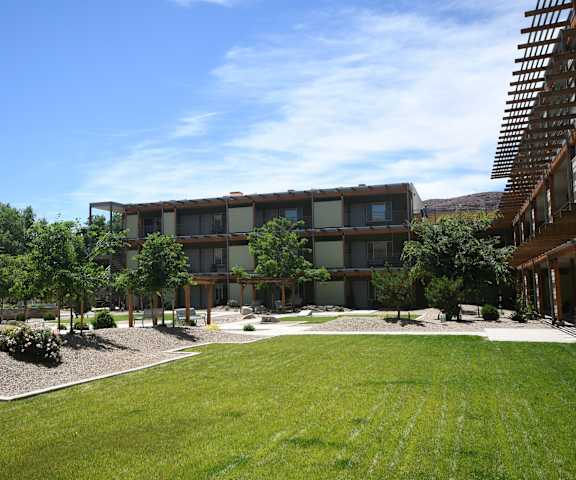 a view of the courtyard of a building with grass and trees