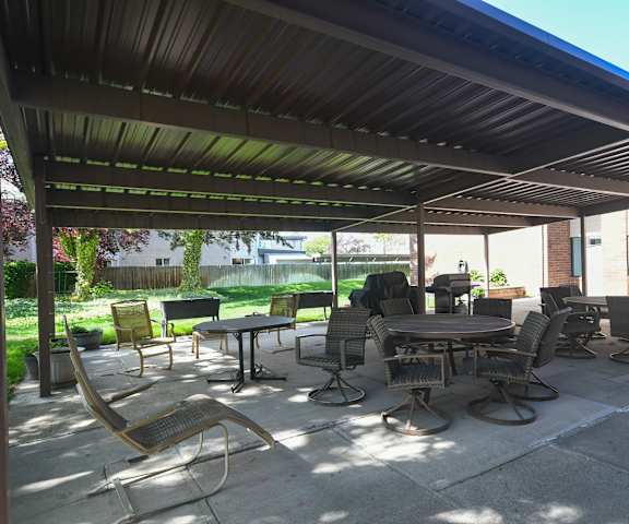a patio with tables and chairs under awning