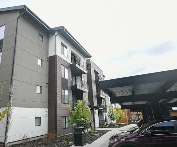 the exterior of a building with cars parked in front of it
