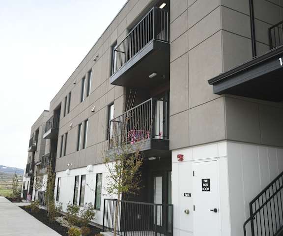 a row of apartment buildings with a sidewalk in front of them