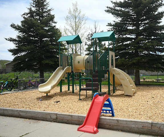 a playground with a mix of slides and climbing equipment in a park