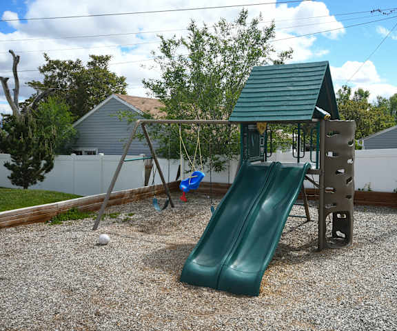 a playground with a swing set and a slide