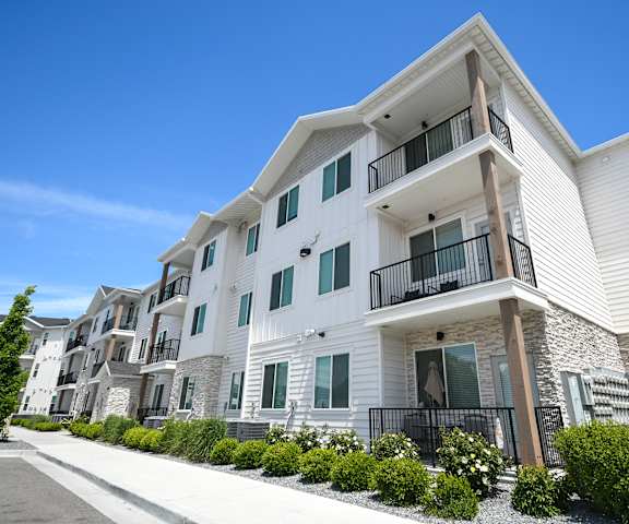 a row of white apartments with balconies and a sidewalk