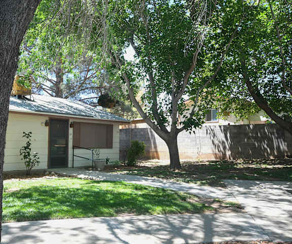a house with a yard and trees in front of it