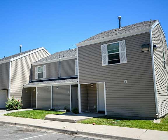 a row of houses with gray siding and a blue sky