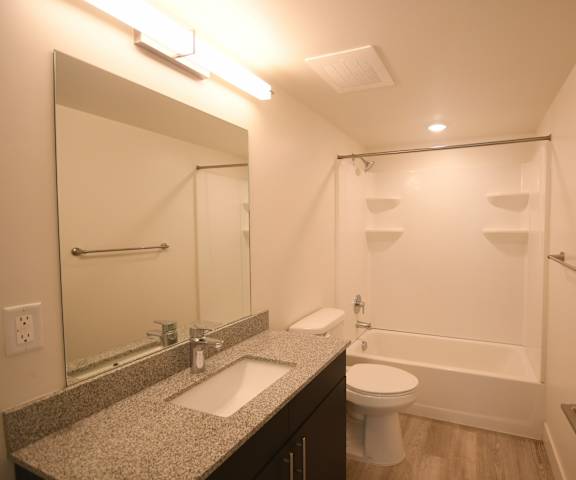 a bathroom with a shower sink and toilet and a mirror