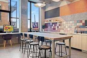 A kitchen with a bar area and a painting on the table.