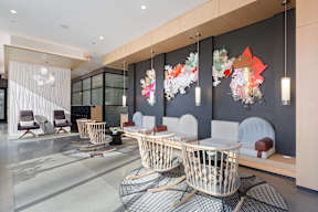 A modern waiting room with white chairs and a grey wall.