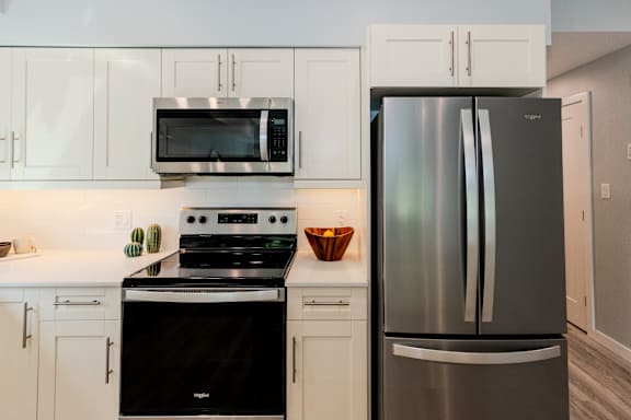 A modern kitchen with a stainless steel refrigerator and black oven.