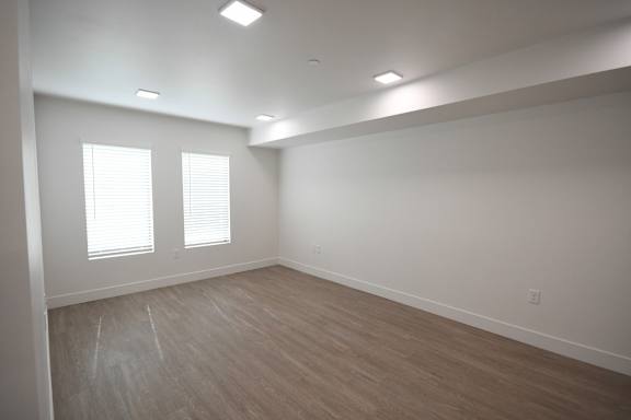 an empty room with wood floors and white walls