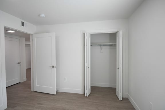 an empty bedroom with white walls and a closet