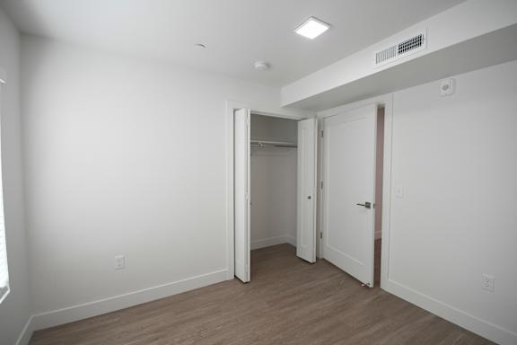 an empty room with white walls and a door to a closet