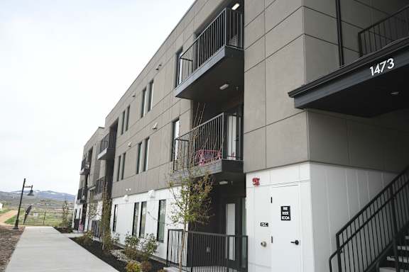 a row of apartment buildings with a sidewalk in front of them