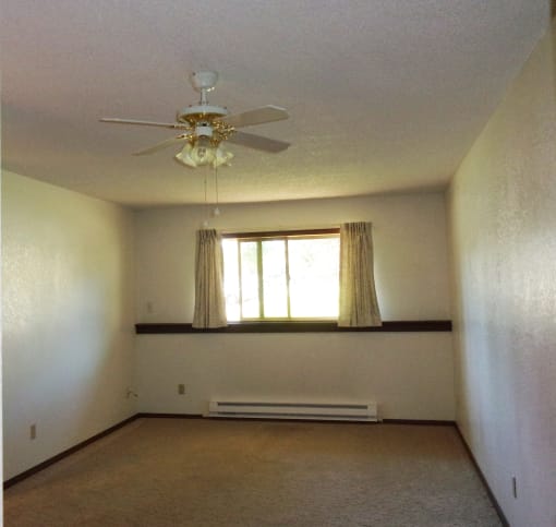 Image of bedroom with overhead fan, base board heater, and window