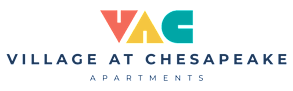 A sign that says "Village at Chesapeake Apartments" in black and white.