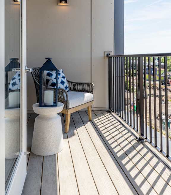 A balcony with a white pillar and a black railing.
