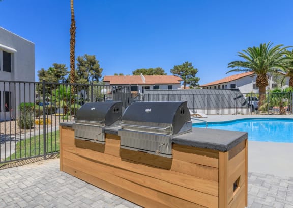 a patio with a grill and a swimming pool