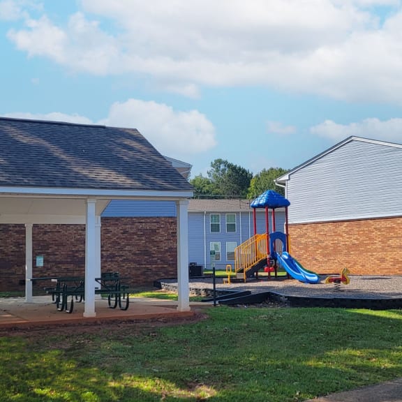 a house with a yard with a playground and a pavilion