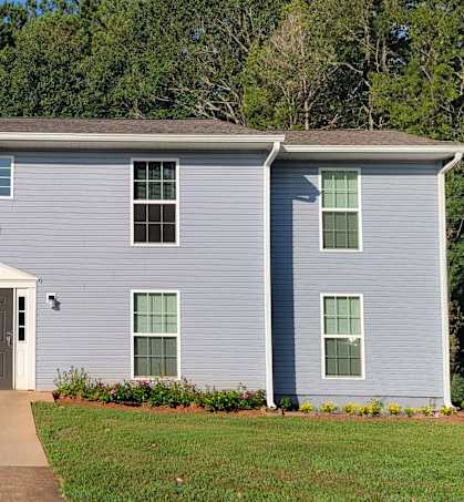 a white house with a sidewalk in front of it
