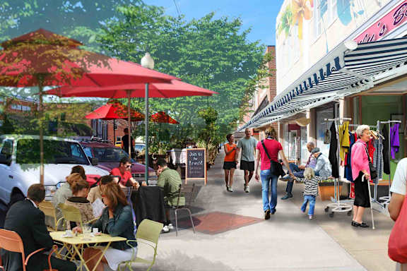 A busy outdoor cafe scene with people sitting and walking around.