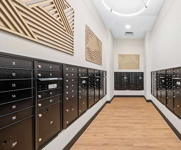 A long hallway with black mailboxes on either side.
