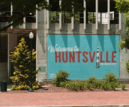 A sign welcoming people to Huntsville is on a building.