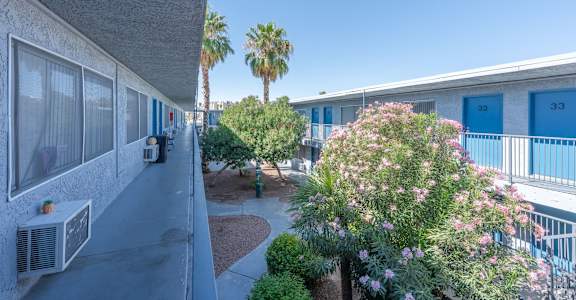 A balcony with a view of apartment buildings and palm trees.
