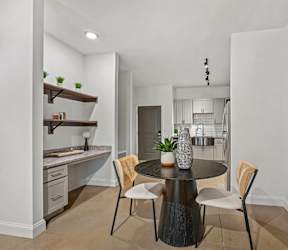 A modern kitchen with a dining table set for two.