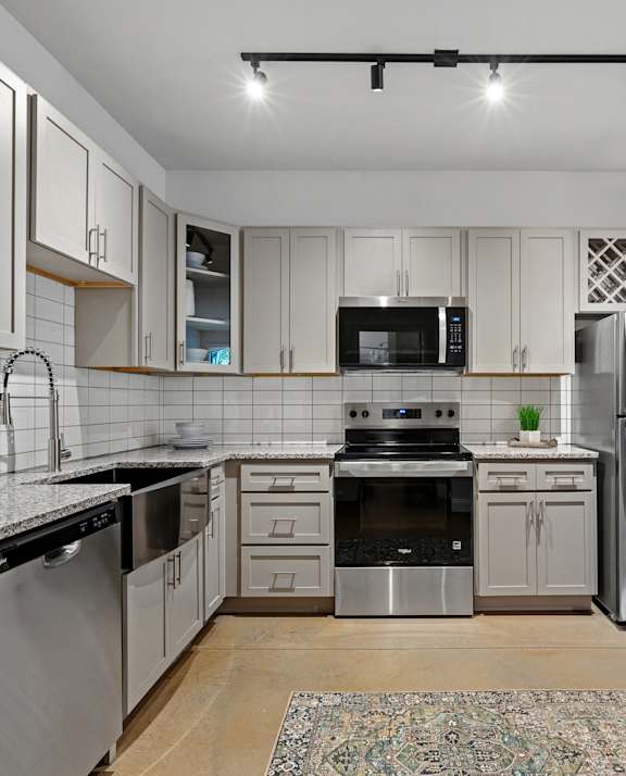 A modern kitchen with stainless steel appliances and wooden floors.