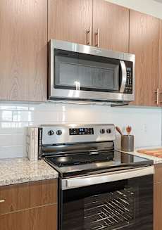 A kitchen with a stove, microwave, and refrigerator.