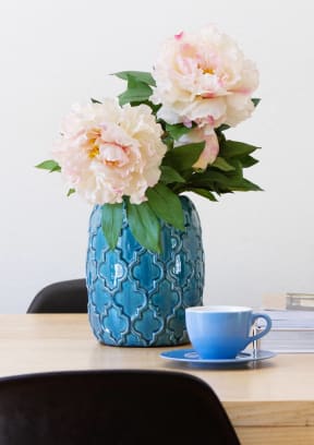 a table with a vase of flowers and a stack of books
