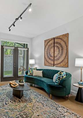 A living room with a wooden floor and a grey sofa.