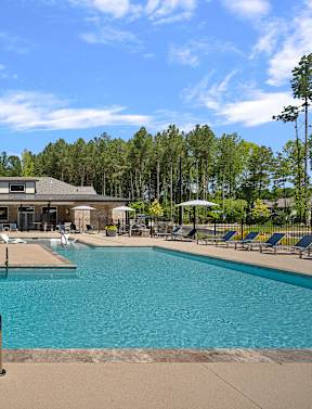 A large swimming pool with a building in the background.