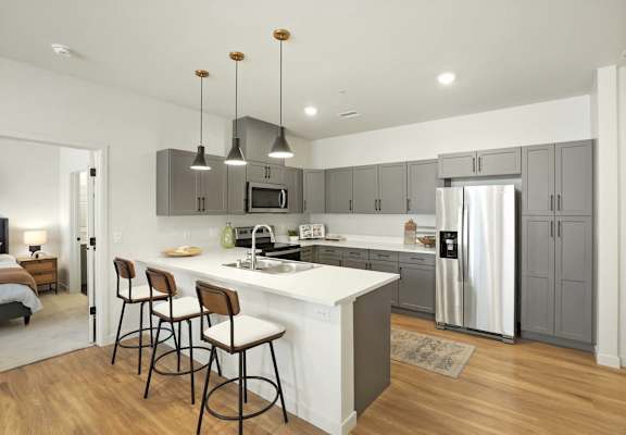 A modern kitchen with a white island and stainless steel appliances.