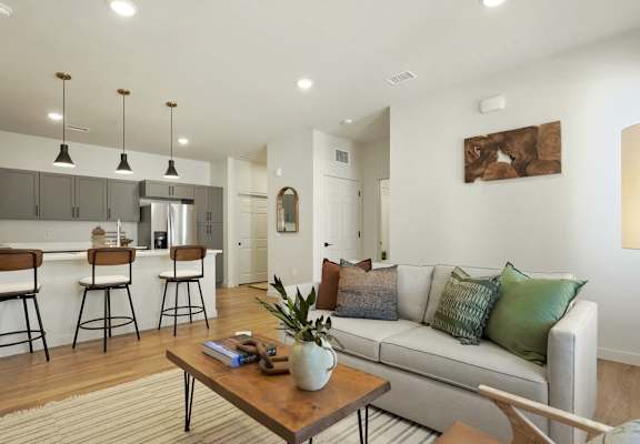 A modern living room with a white couch and a wooden coffee table.