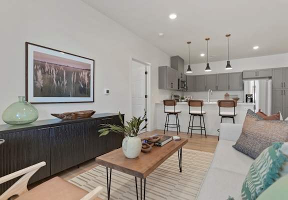 a living room and kitchen with a couch and a table