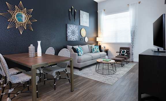 a living and dining room area with a couch table and chairs and a tv on a stand