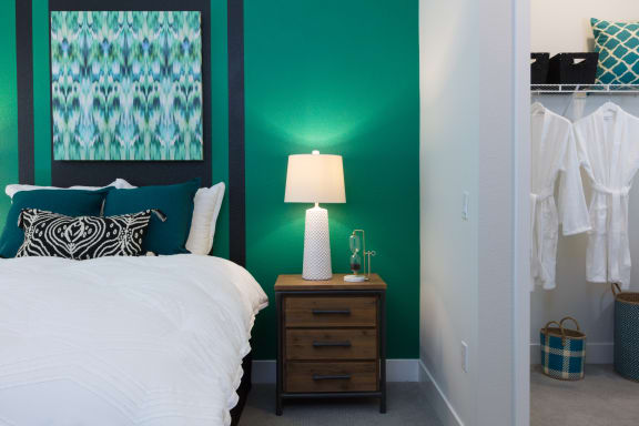 a bedroom with a green accent wall and white bedding