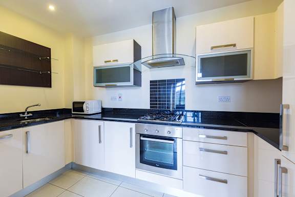 a kitchen with black counter tops and white cabinets